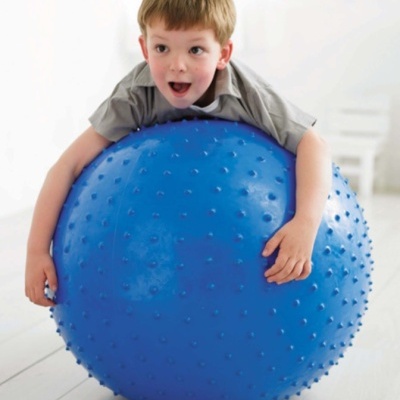 Criança com bola de exercício azul texturada