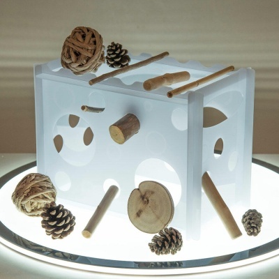 Estrutura branca translúcida com paus, pinhas e bolas de rattan decorativas