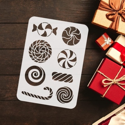 Stencil branco com recortes de doces ao lado de caixas de presente coloridas