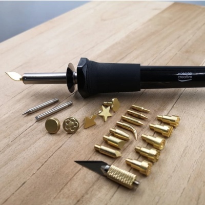 Ferramentas para pirografia com várias pontas e cabo preto em madeira