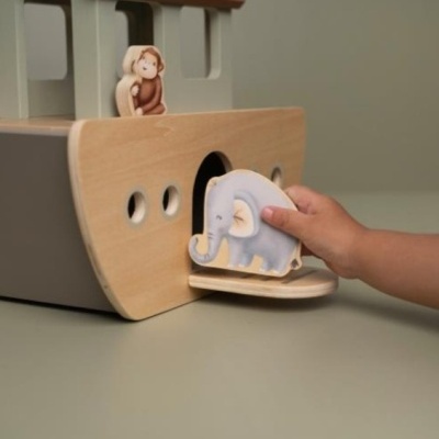 Brinquedo de madeira com figuras de animais, elefante e macaco, em fundo neutro