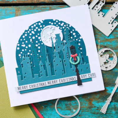 Cartão de Natal tridimensional com cidade, lua, candeeiro e texto MERRY CHRISTMAS