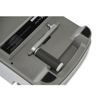 Peça mecânica cinza com pega preta e detalhes metálicos sobre superfície cinza