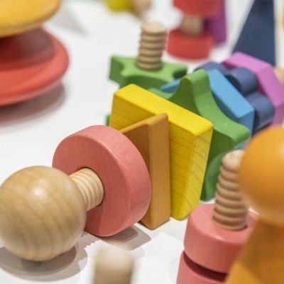 Brinquedo de madeira colorido com parafusos e blocos geométricos