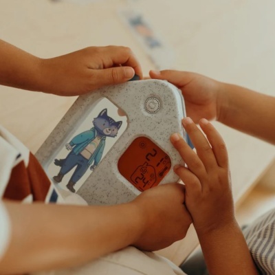 Monitor digital infantil branco com visor laranja e figura de lobo azul desenhado