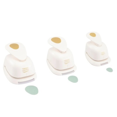 Três furadores de papel brancos com alças bege e formas de recorte diferentes em fundo branco.