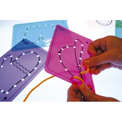 Mãos manipulando fio de lã em painel plástico colorido com orifícios