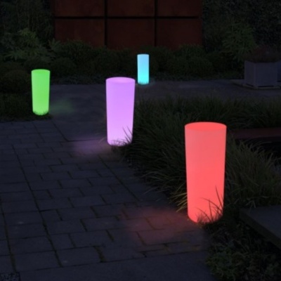 Colunas iluminadas de várias cores ao longo de caminho de pedra exterior