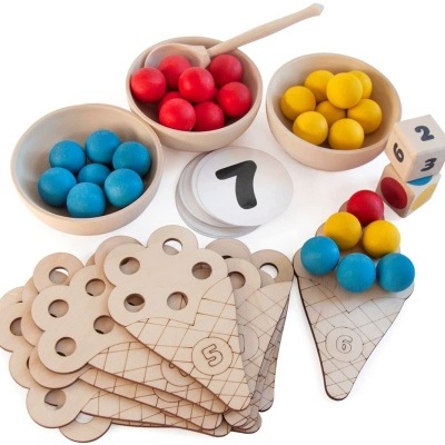 Jogo educativo com bolas coloridas e componentes de madeira claros