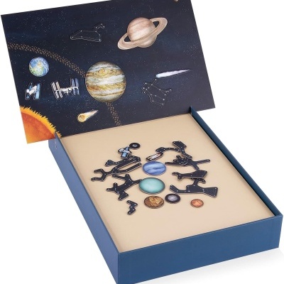 Quebra-cabeça do sistema solar com peças coloridas numa caixa azul com ilustração espacial na tampa