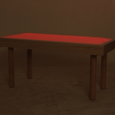 Mesa retangular com tampo vermelho iluminado e pernas de madeira