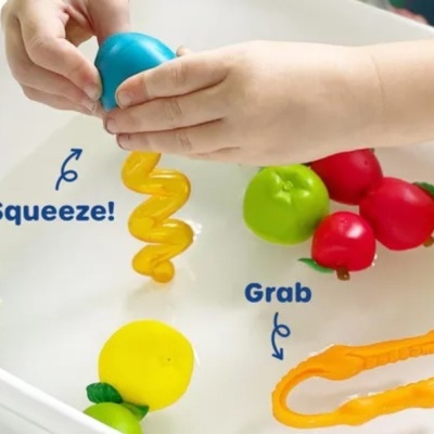 Brinquedos de plástico coloridos para crianças em tabuleiro branco com texto explicativo