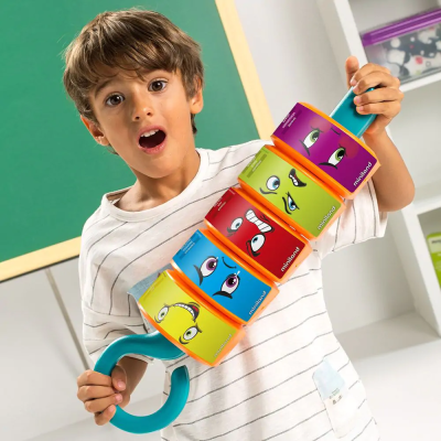 Criança segurando brinquedo colorido com blocos de caras expressivas empilhados