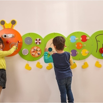 Painel de atividades infantil em forma de lagarta, colorido, com crianças a brincar