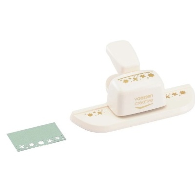 Perfurador de papel branco com flores douradas e tira verde perfurada