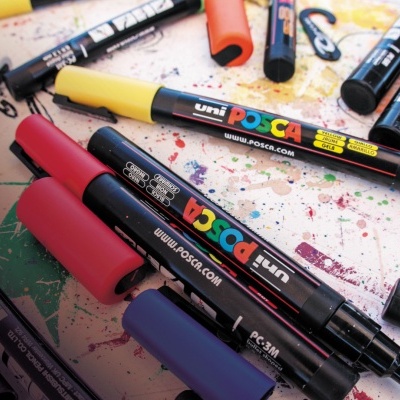 Marcadores Uni Posca coloridos sobre superfície manchada