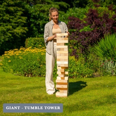Mulher a jogar jogo de torre gigante em madeira num jardim