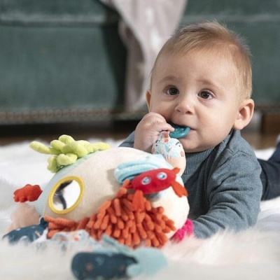 Bebé a brincar com brinquedo de pelúcia colorido