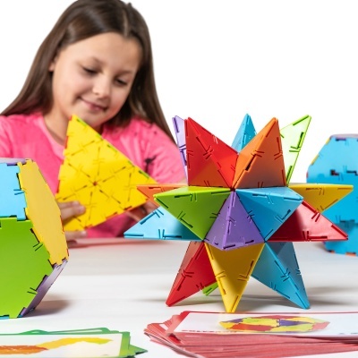 Brinquedo de construção plástico colorido com peças triangulares e estruturas geométricas.