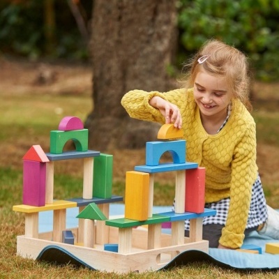 Menina a brincar com blocos de construção de madeira coloridos