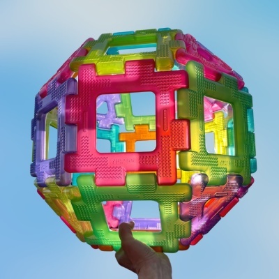 Esfera colorida feita de peças plásticas encaixáveis translúcidas com textura rugosa