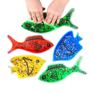 Cinco peixes coloridos de plástico com glitter em forma de estrelas e rosto desenhado, mãos pressionam peixe verde