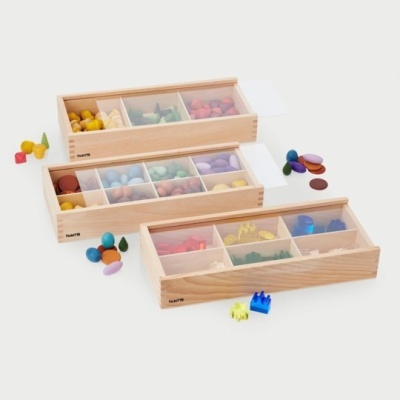 Caixas organizadoras de madeira com compartimentos e peças coloridas diversas