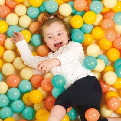 Criança a brincar em bolas de plástico coloridas