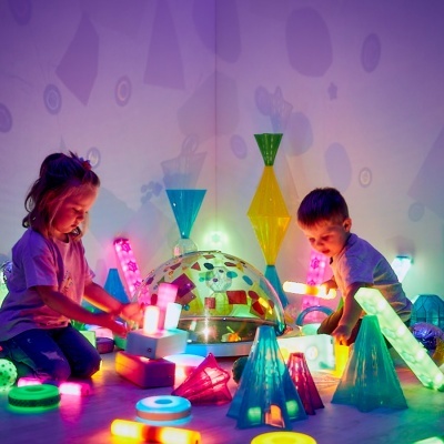 Crianças a brincar com brinquedos luminosos coloridos em ambiente interior