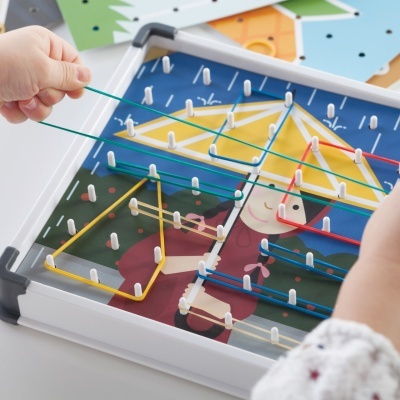 Jogo de tabuleiro com elásticos coloridos esticados em peças brancas sobre base ilustrada