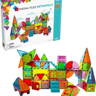 Conjunto magnético MAGNA-TILES METROPOLIS com peças coloridas e montagens em castelo e veículos, caixa colorida ao fundo.