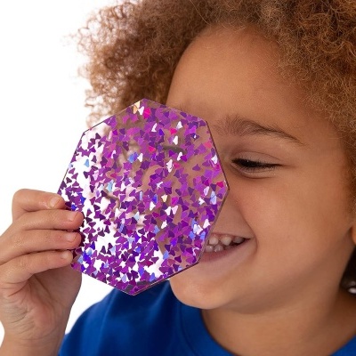 Criança segura objeto octagonal roxo com confetes refletivos