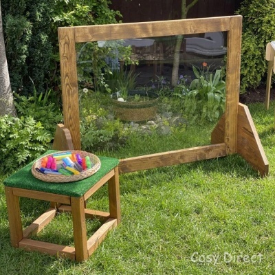 Quadro branco magnético com suporte de madeira e banco com marcadores coloridos no jardim