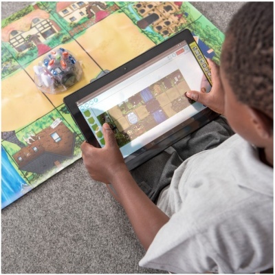Criança usando tablet com tapete de jogo colorido ao fundo