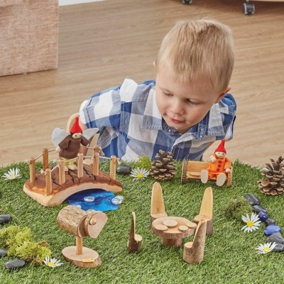 Brinquedo de madeira e criança brincando em relvado artificial