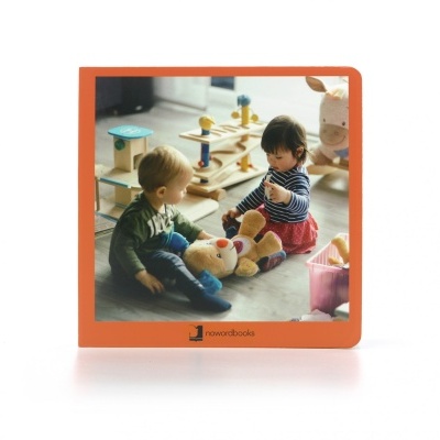 Livro infantil com capa dura e fotografia de crianças a brincar com brinquedos