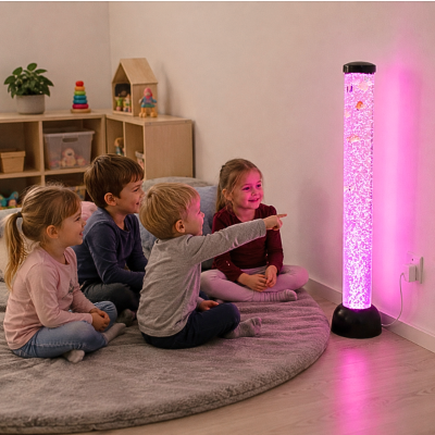 Crianças sentadas num tapete perto de coluna luminosa rosa com bolhas e peixes