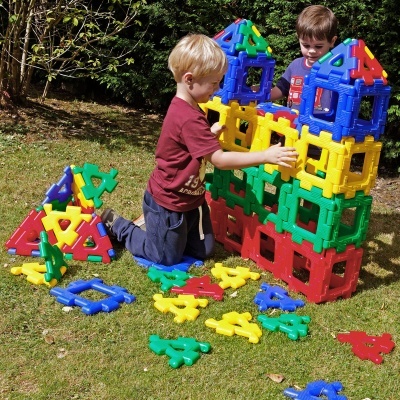 Crianças a construir com blocos de construção coloridos no jardim
