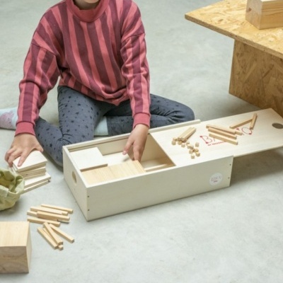 Criança a brincar com jogo de construção em madeira natural