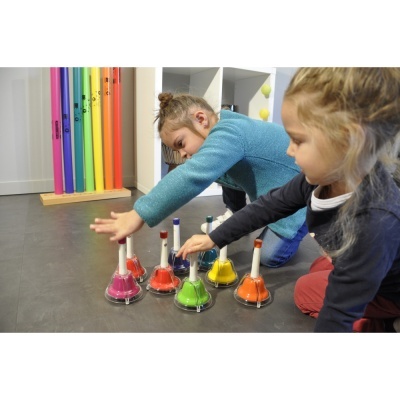 Crianças a tocar sinos coloridos no chão