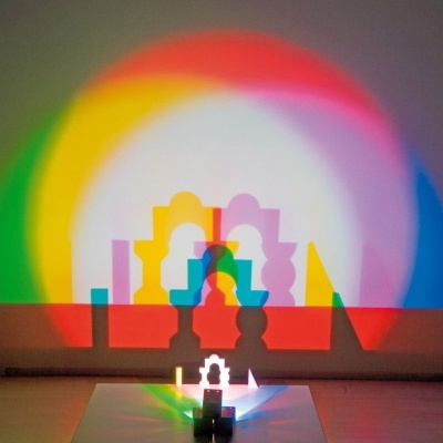 Lâmpada colorida refletindo luzes e sombras coloridas numa parede