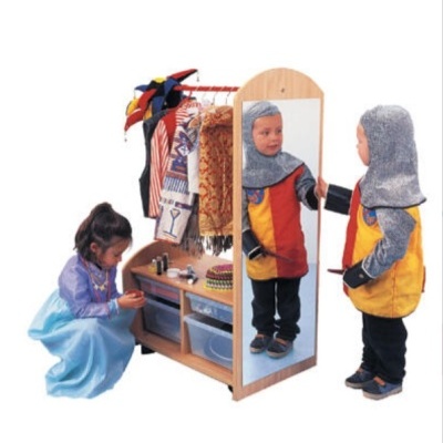 Móvel de madeira infantil com espelho e roupas penduradas, com duas crianças vestidas com fatos de fantasia
