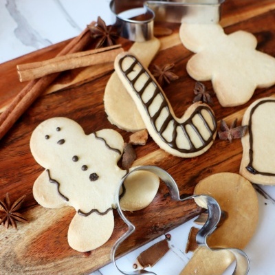 Biscoitos decorados em formas natalinas com glacê e moldes metálicos