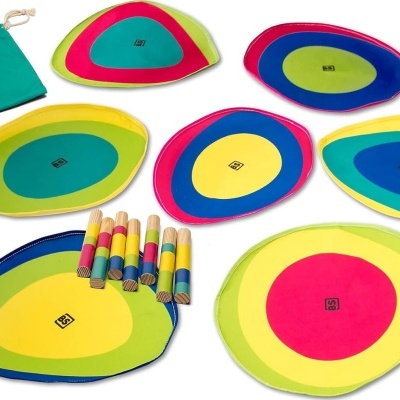 Jogo de coordenação com alvos ovais coloridos e cilindros de madeira com saco verde