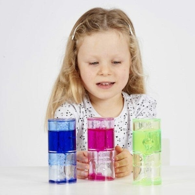 Copos coloridos empilhados na frente de criança loira