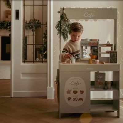 Criança a brincar num quiosque de brinquedo de café com acessórios em madeira