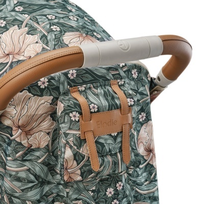 Carrinho de bebé com padrão floral e alça de pele castanha