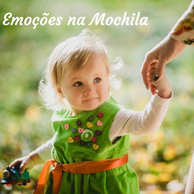 Criança com vestido verde segurando mão de adulto e brinquedo em ambiente ao ar livre