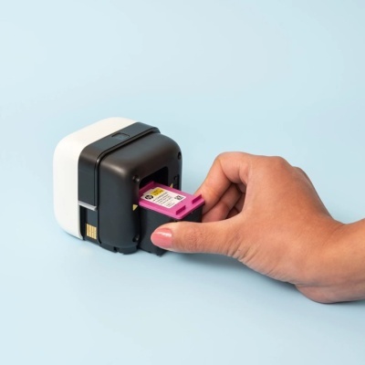 Dispositivo de impressão compacto e mão a inserir cartucho de tinta