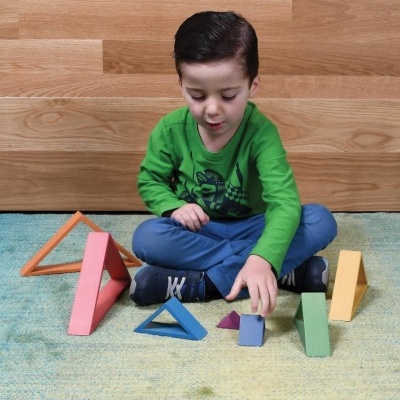 Criança a brincar no chão com blocos de madeira coloridos